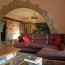 The half of the lounge showing the stone arch leading to the inglenook fireplace and the door to the bedrooms. 